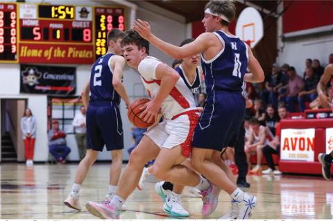 Grayson Ratzlaffff battles through the defense on his way to the basket. Photos by Barb Pechous