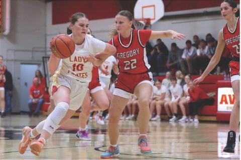 Rilyn Thury drives toward the basket, dribbling past a Gregory d efender during game action.