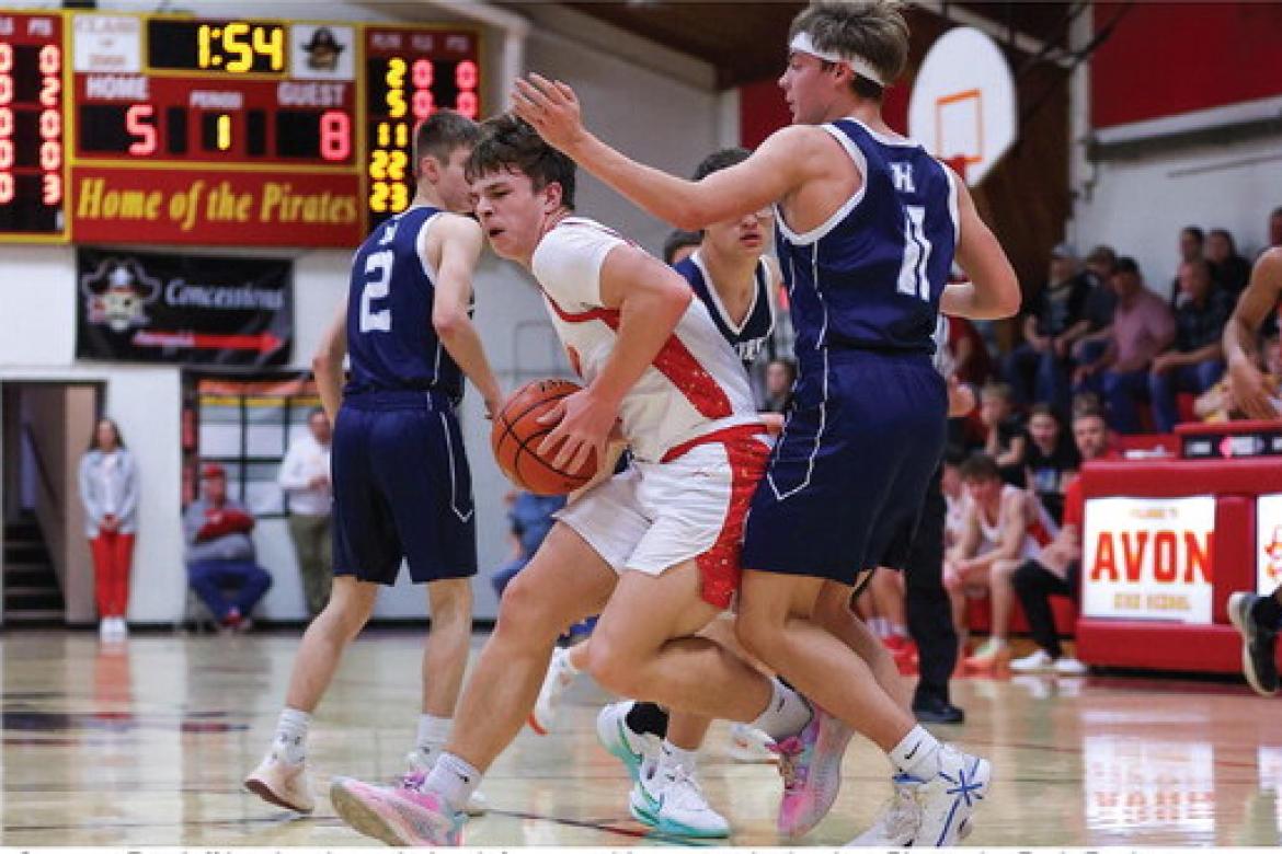 Grayson Ratzlaffff battles through the defense on his way to the basket. Photos by Barb Pechous